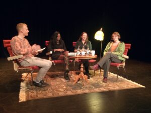Fyra glada personer som sitter på en scen